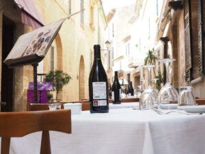 Hygiene At Your Restaurant- Image of a outdoor restaurant table with clean glasses, wine and white table linen