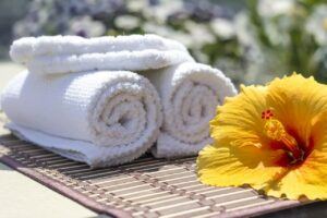 Spa Centers-Image of two clean and rolled up white towels in a spa setting